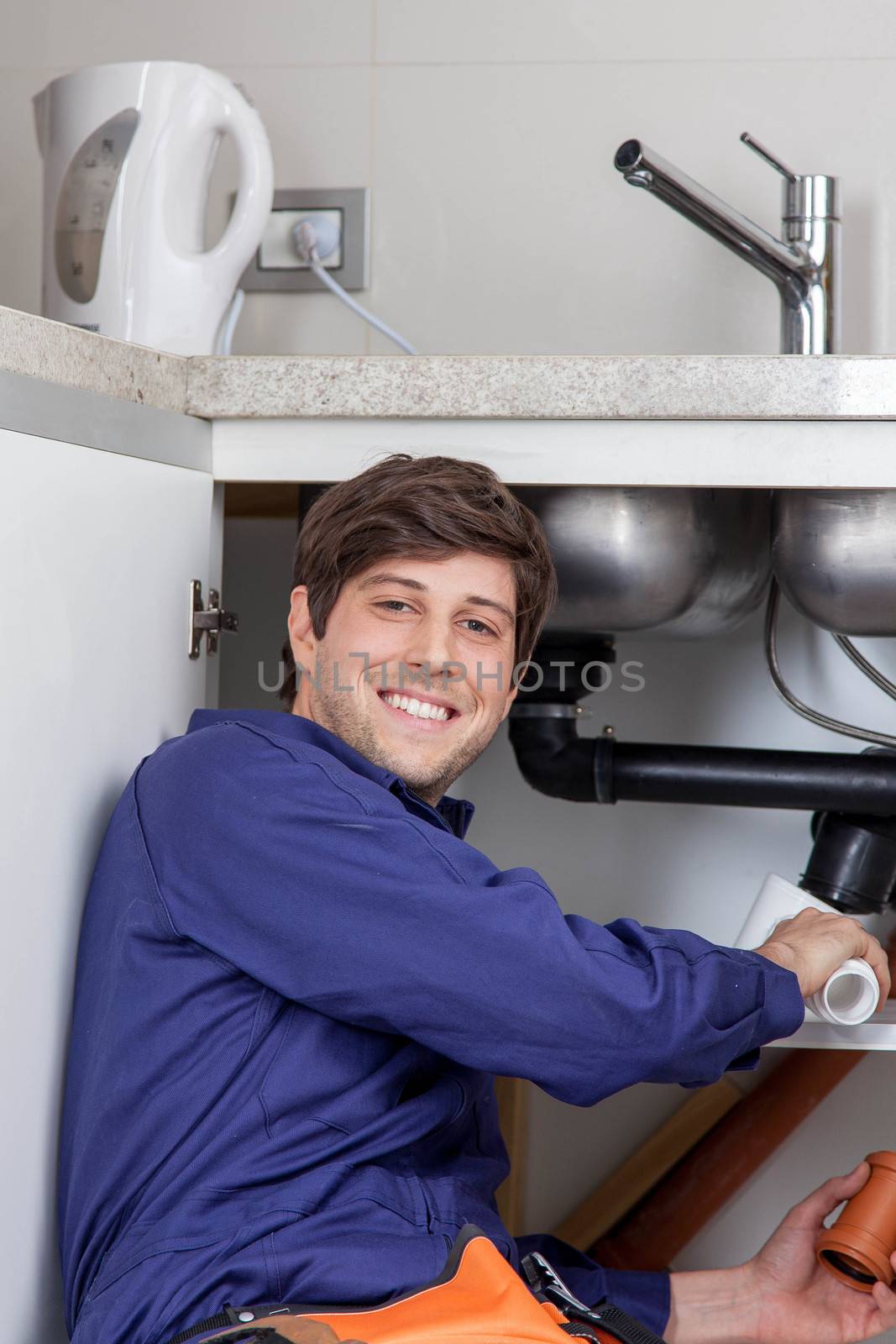 Happy plumber placing a pipe