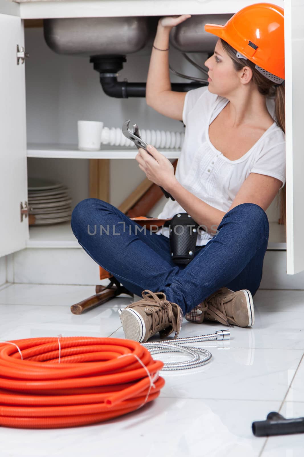 Woman working in the pipe of the kitchen