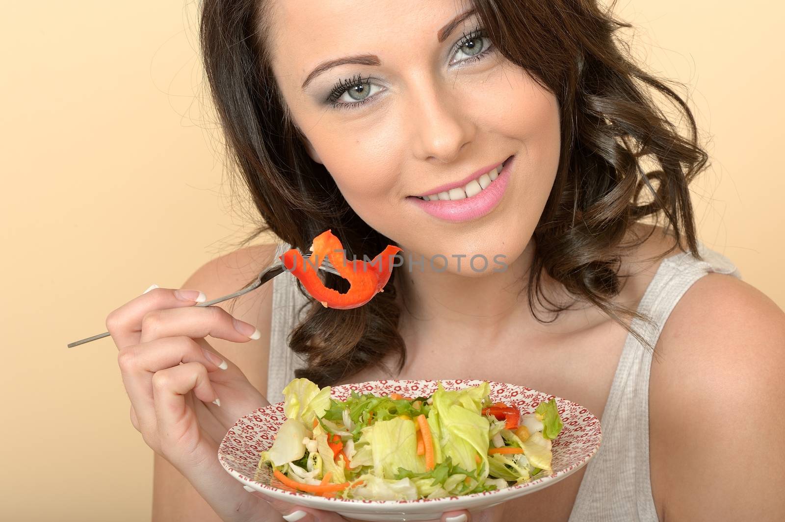 Attractive Beautiful Young Woman Looking at the Camera Eating a  by Whiteboxmedia