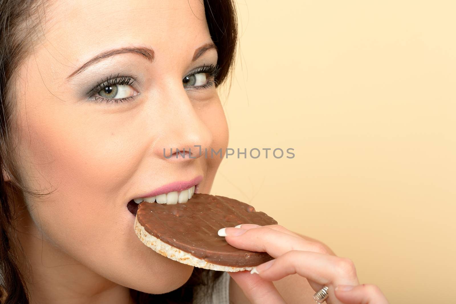 Attractive Beautiful Young Woman Eating a Single Milk Chocolate Covered Rice Cake Biscuit