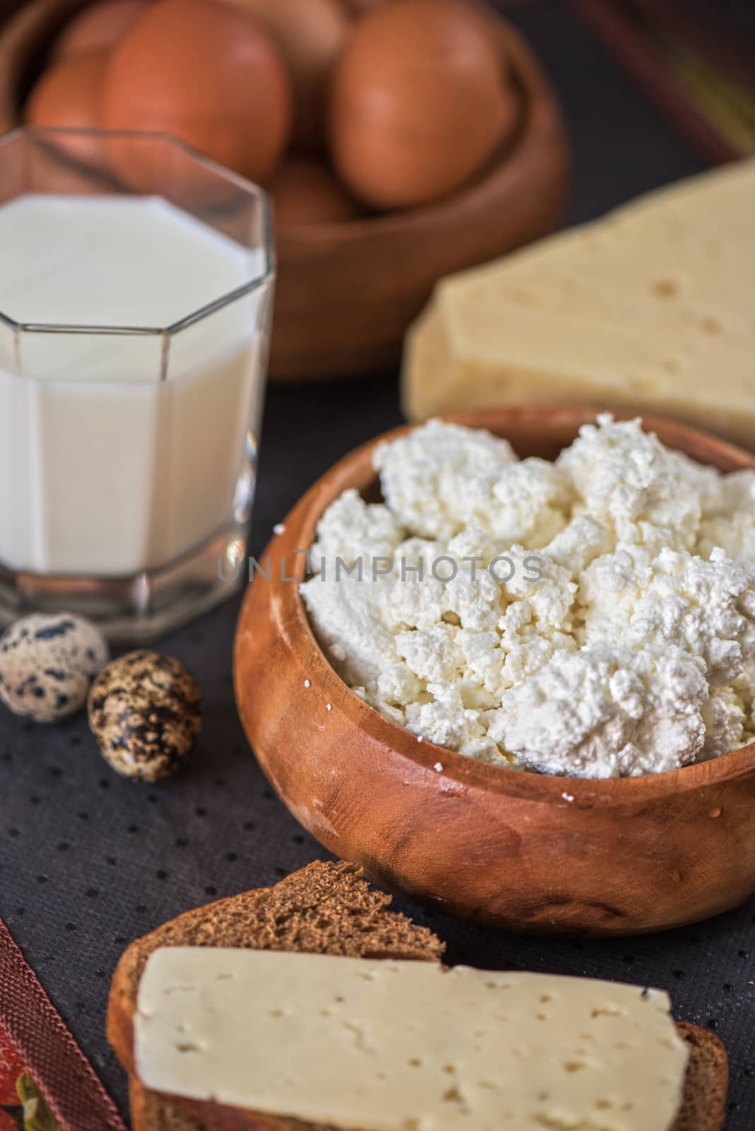 still life with dairy products as milk, cheese cottage cheese eggs and bread 