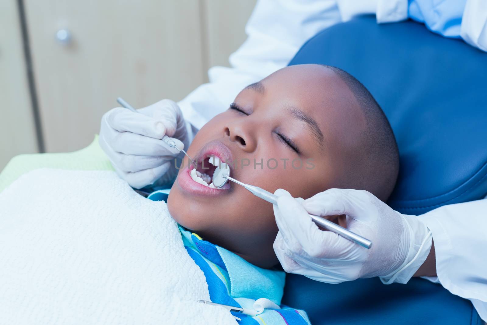 Close up of boy having his teeth examined by Wavebreakmedia