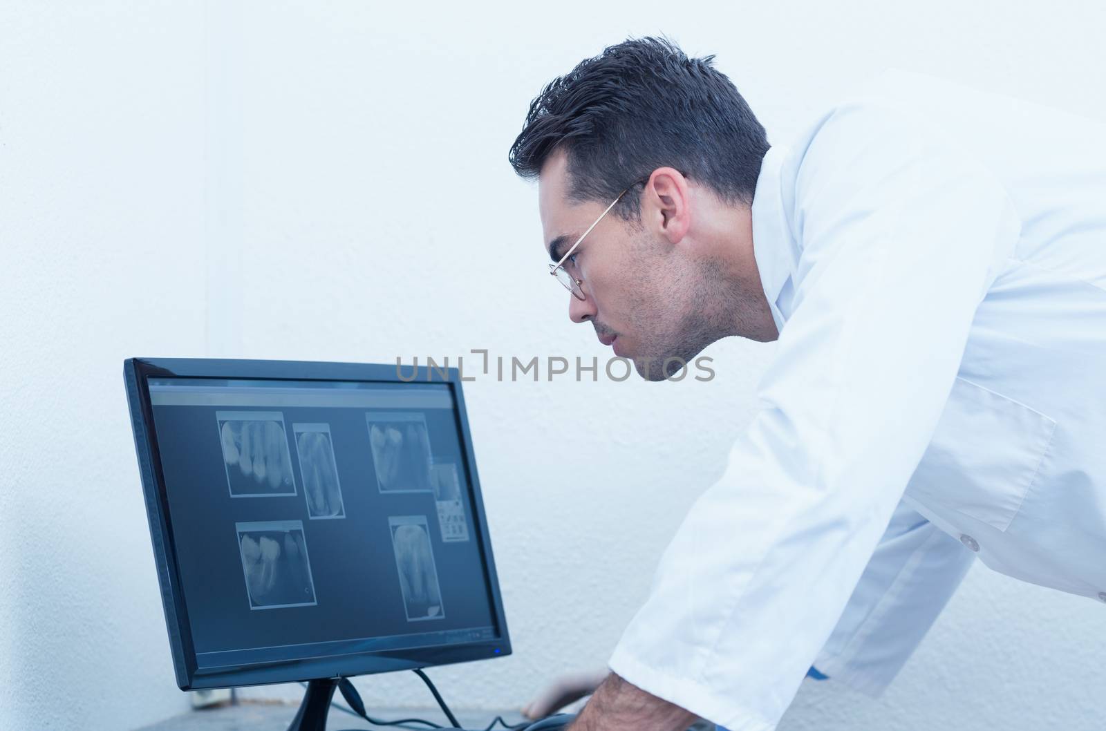 Dentist looking at x-ray on computer by Wavebreakmedia