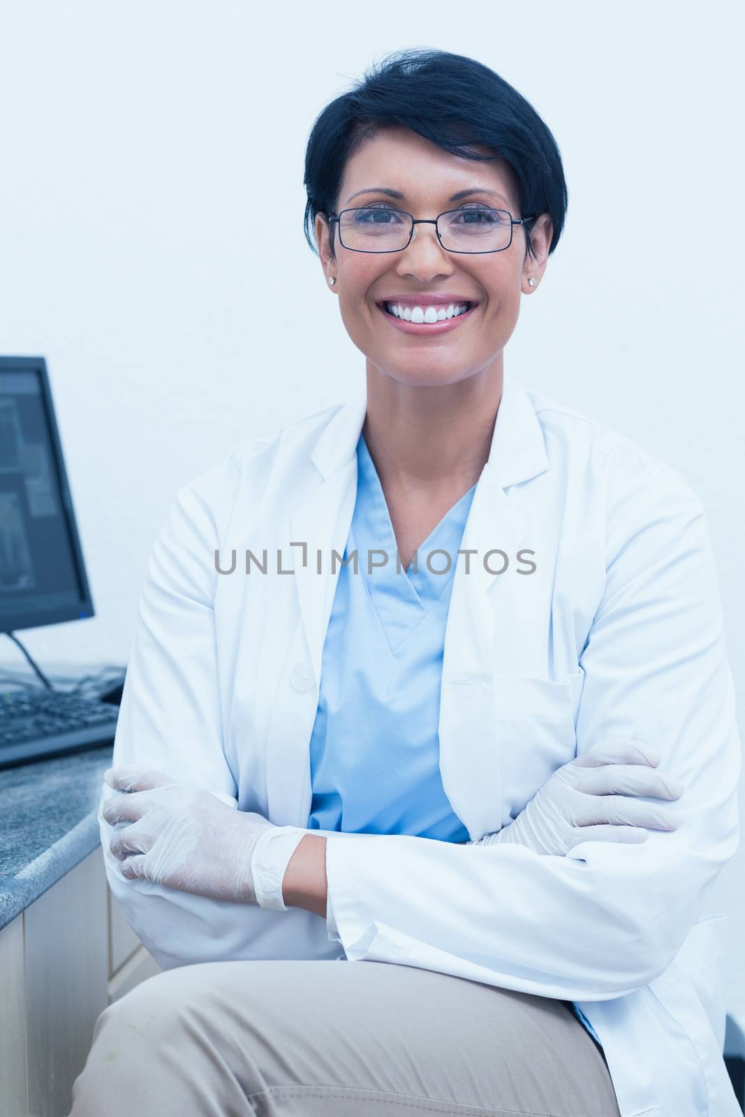 Smiling female dentist with arms crossed by Wavebreakmedia