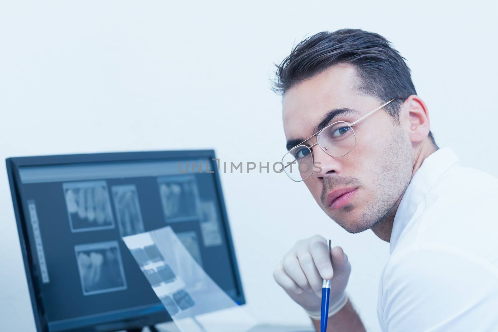 Portrait of male dentist with x-ray on computer
