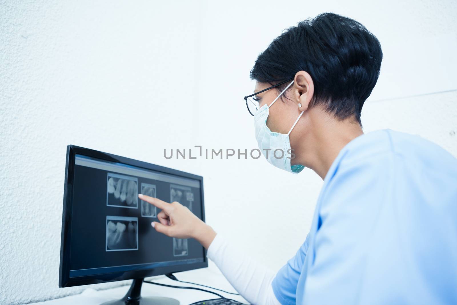 Female dentist looking at x-ray on computer by Wavebreakmedia