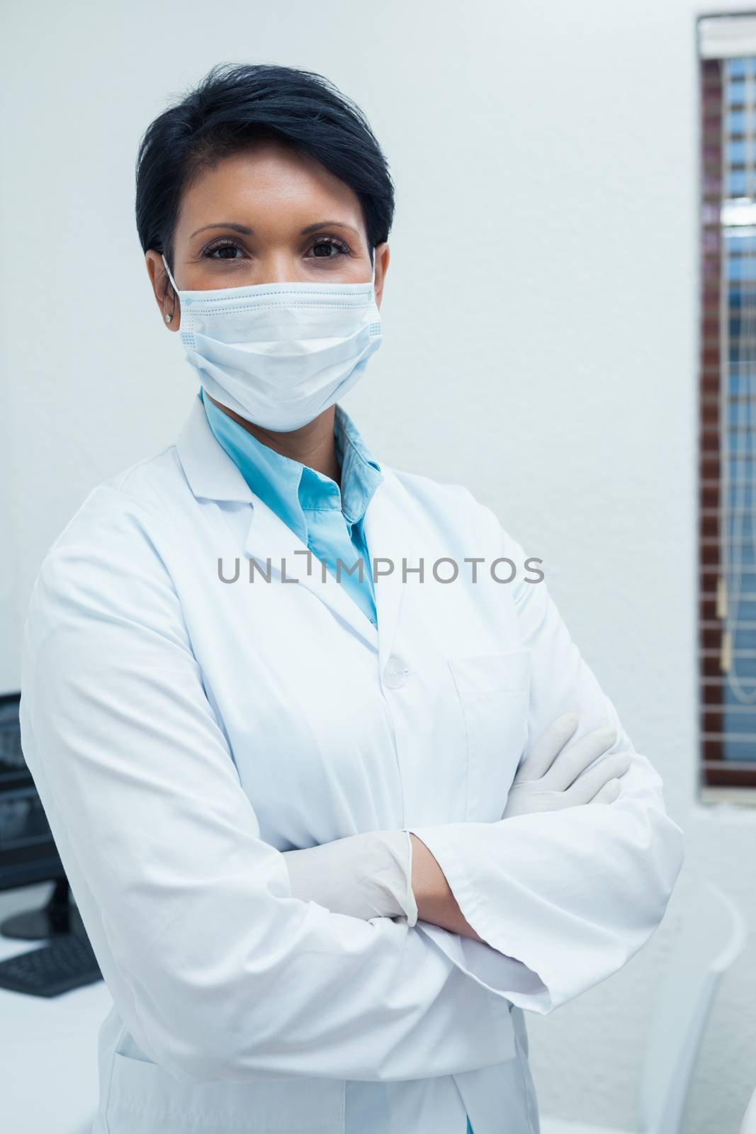 Female dentist wearing surgical mask by Wavebreakmedia