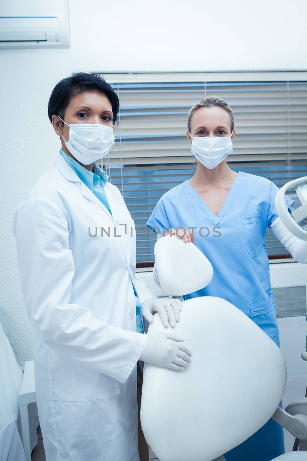 Female dentists wearing surgical masks by Wavebreakmedia