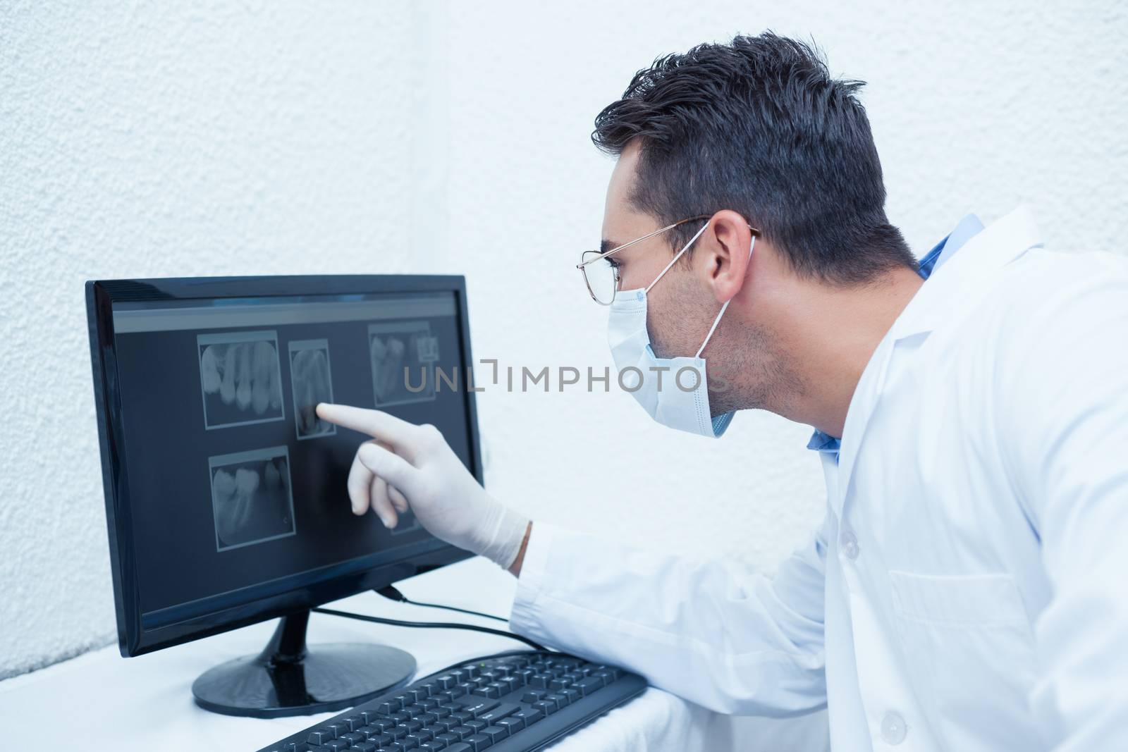 Dentist looking at x-ray on computer by Wavebreakmedia