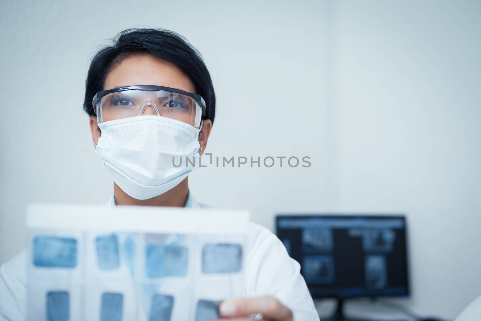 Portrait of serious young female dentist holding x-ray