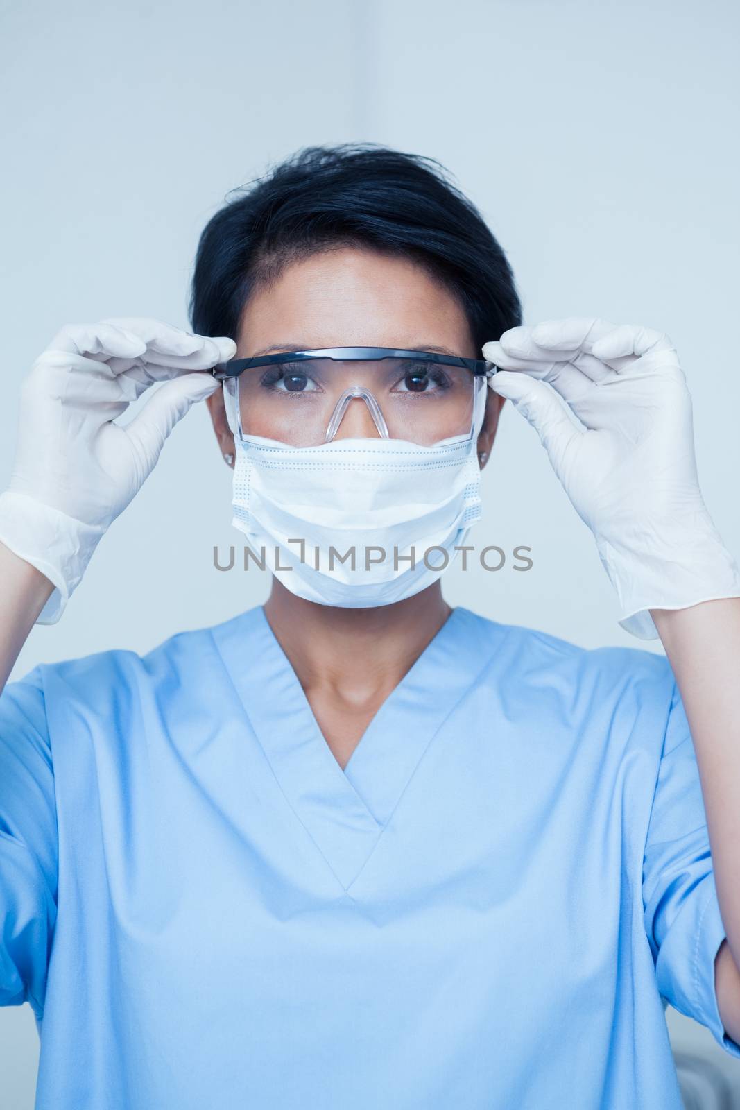 Female dentist wearing surgical mask and safety glasses by Wavebreakmedia