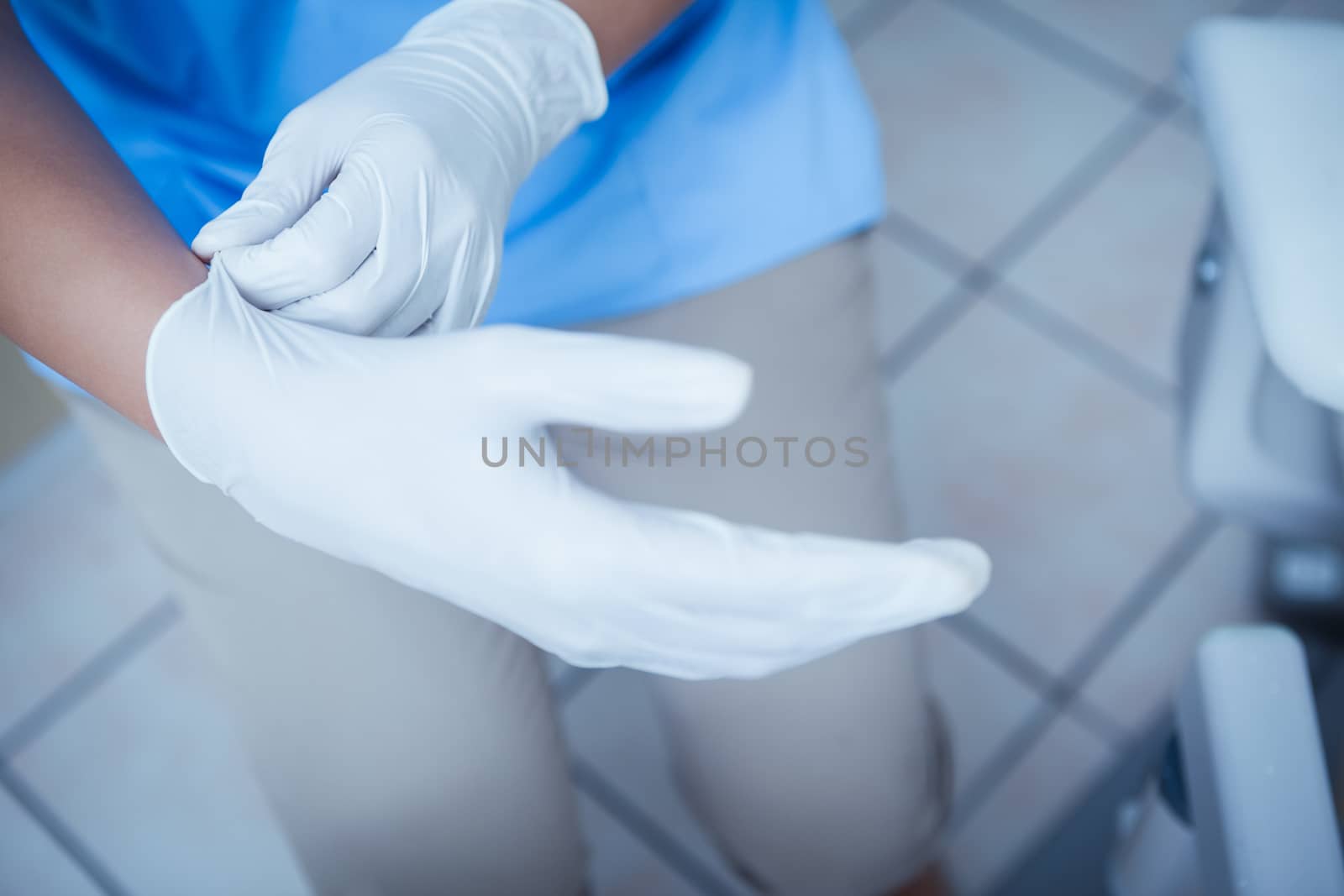 Close up mid section of female dentist wearing surgical glove