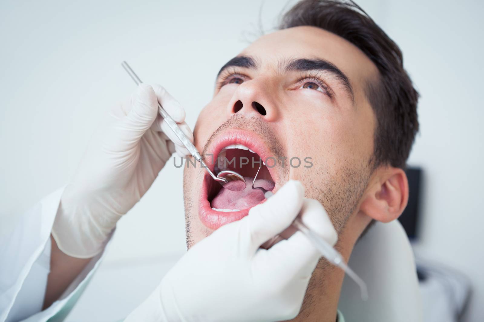 Close up of man having his teeth examined by dentist