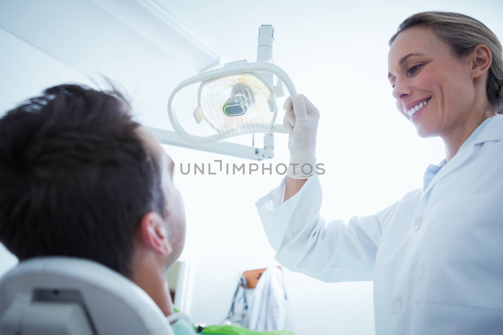 Female dentist examining mans teeth in the dentists chair