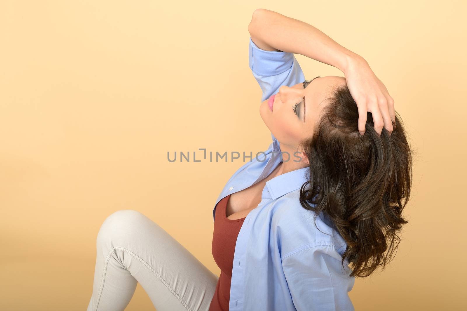 Attractive Young Beautiful Woman Sitting on the Floor Wearing a  by Whiteboxmedia