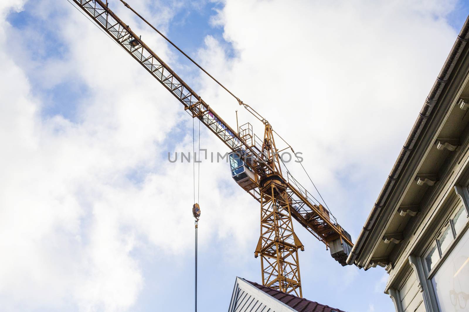 A Tower Crane Overlooking Urban Redevelopment Old Town Stavanger Norway against a Cloudy Sky