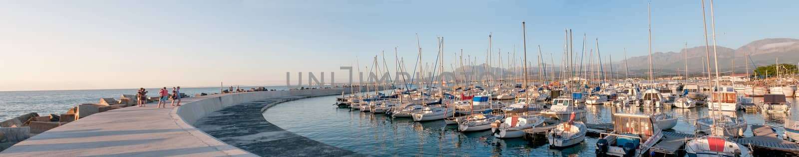 CAPE TOWN, SOUTH AFRICA - DECEMBER 11, 2014:  Sunset panorama of the harbor in Gordons Bay with buildings of Gordons Bay and The Strand in the background