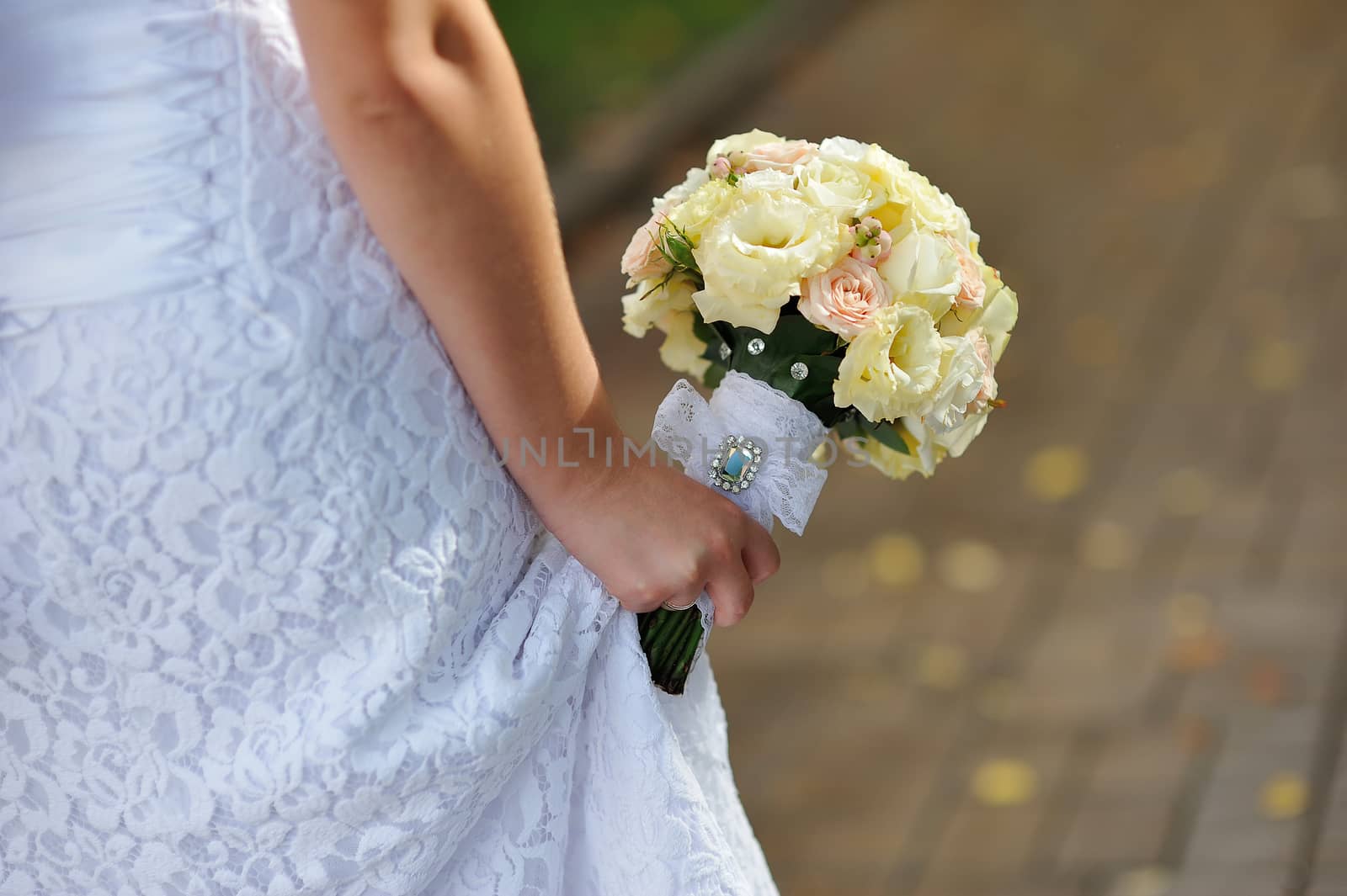 Bride holding white wedding bouquet by timonko