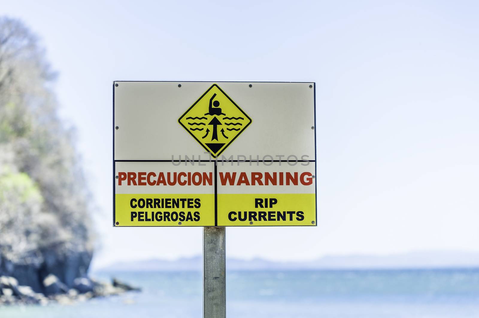 Warning sign for rip currents near an ocean beach.