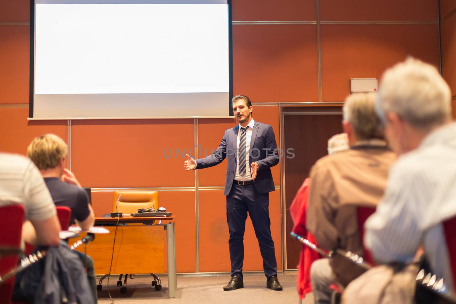 Speaker Giving a Talk at Business Meeting. Audience in the conference hall. Business and Entrepreneurship. Copy space on white board.