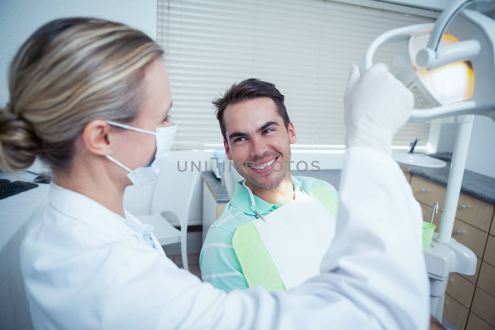 Female dentist examining mans teeth in the dentists chair