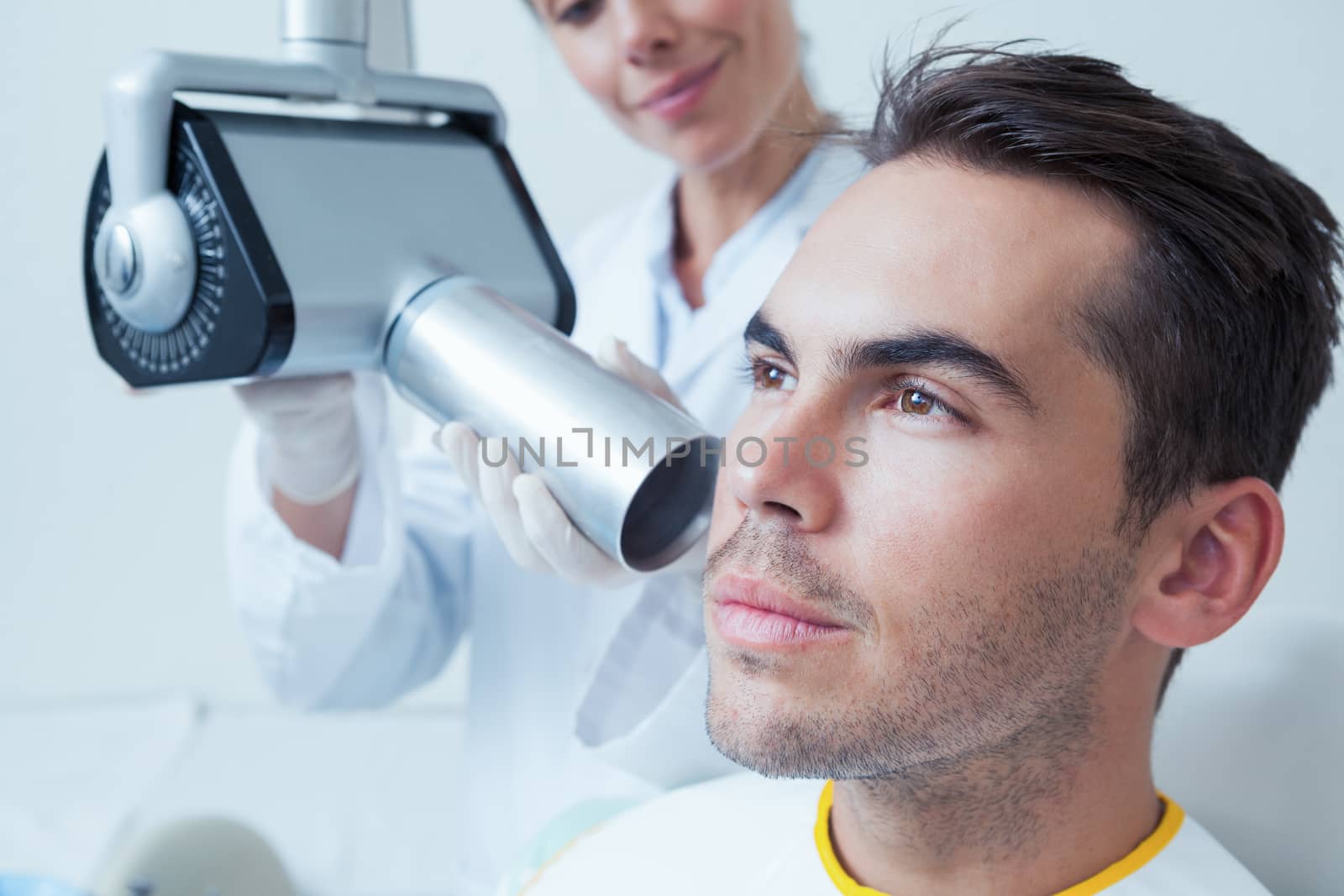 Serious young man undergoing dental checkup by Wavebreakmedia