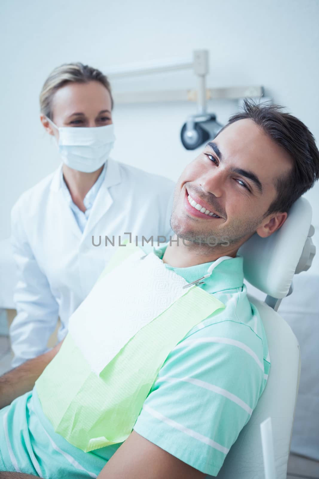 Smiling young man waiting for dental exam by Wavebreakmedia