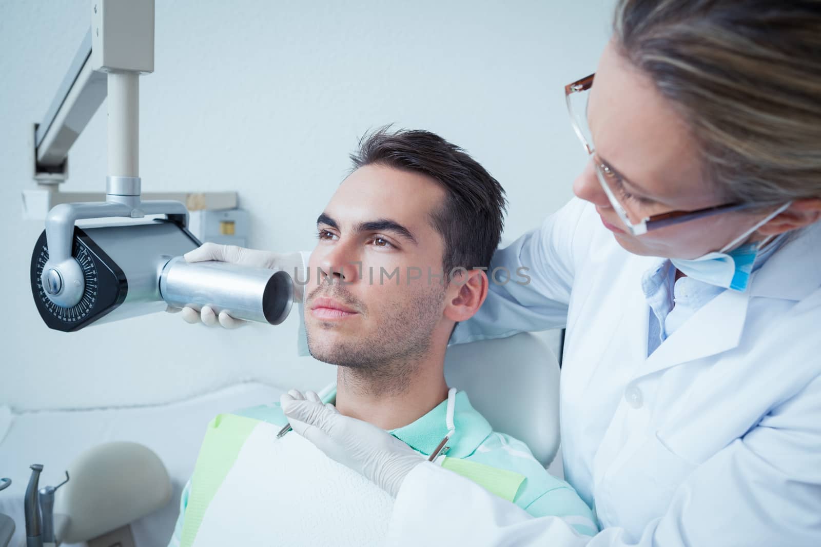 Serious young man undergoing dental checkup by Wavebreakmedia