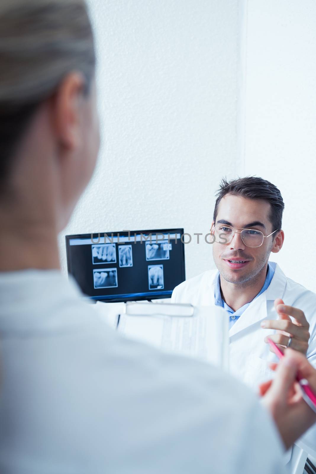 Male and female dentists discussing reports