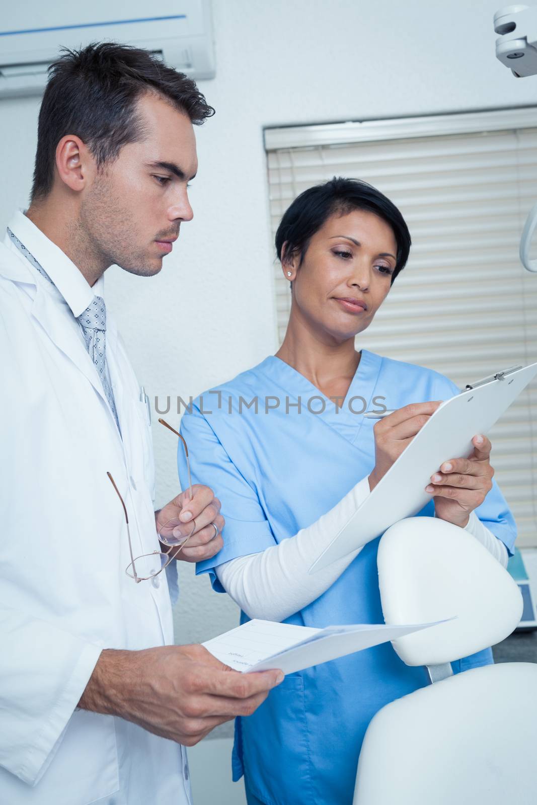 Male and female dentists discussing reports