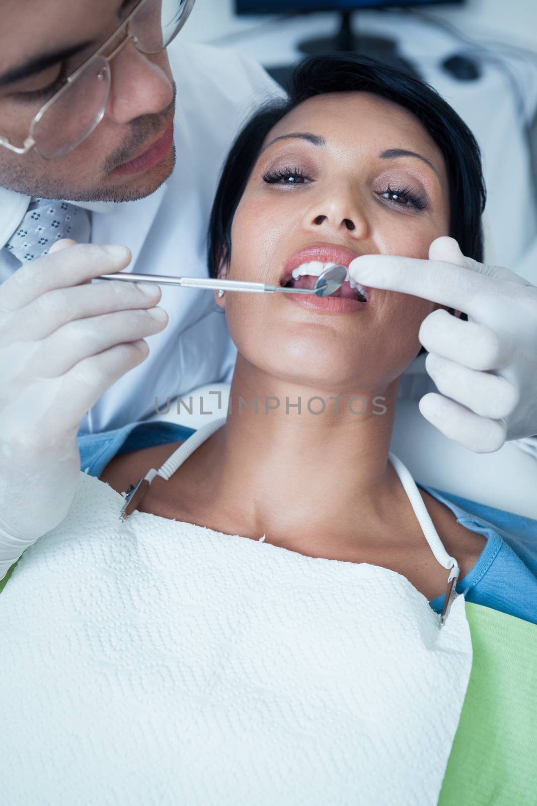 Male dentist examining womans teeth by Wavebreakmedia