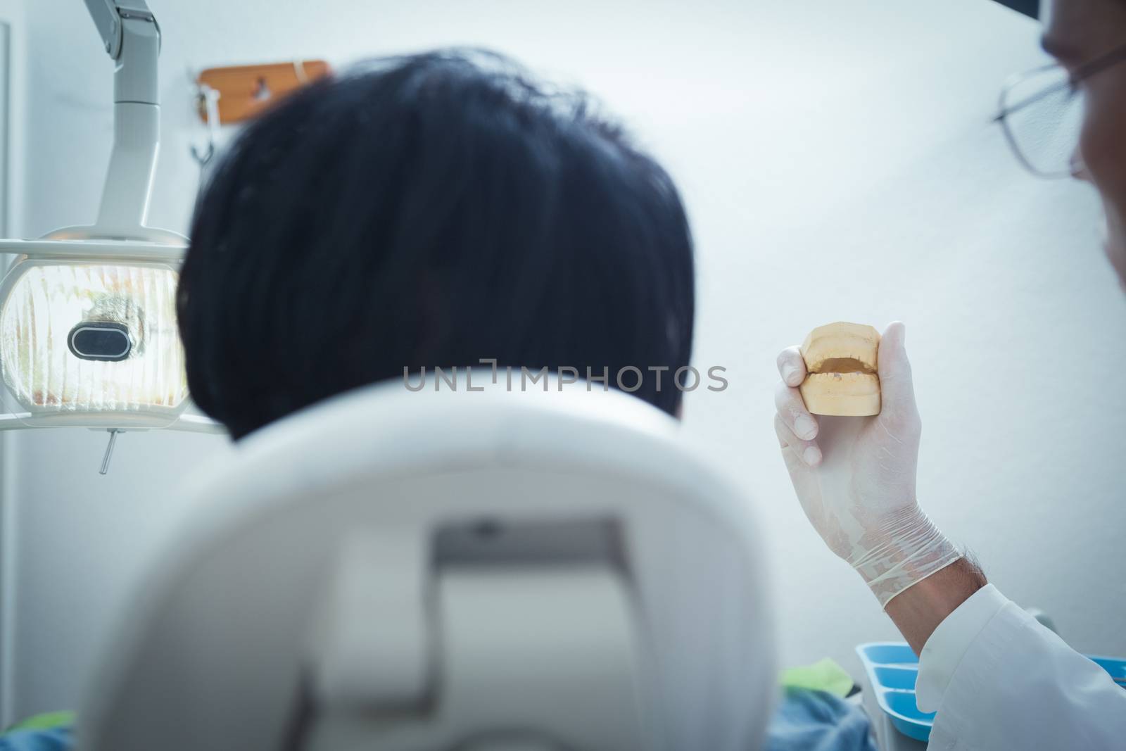 Dentist showing woman model teeth by Wavebreakmedia