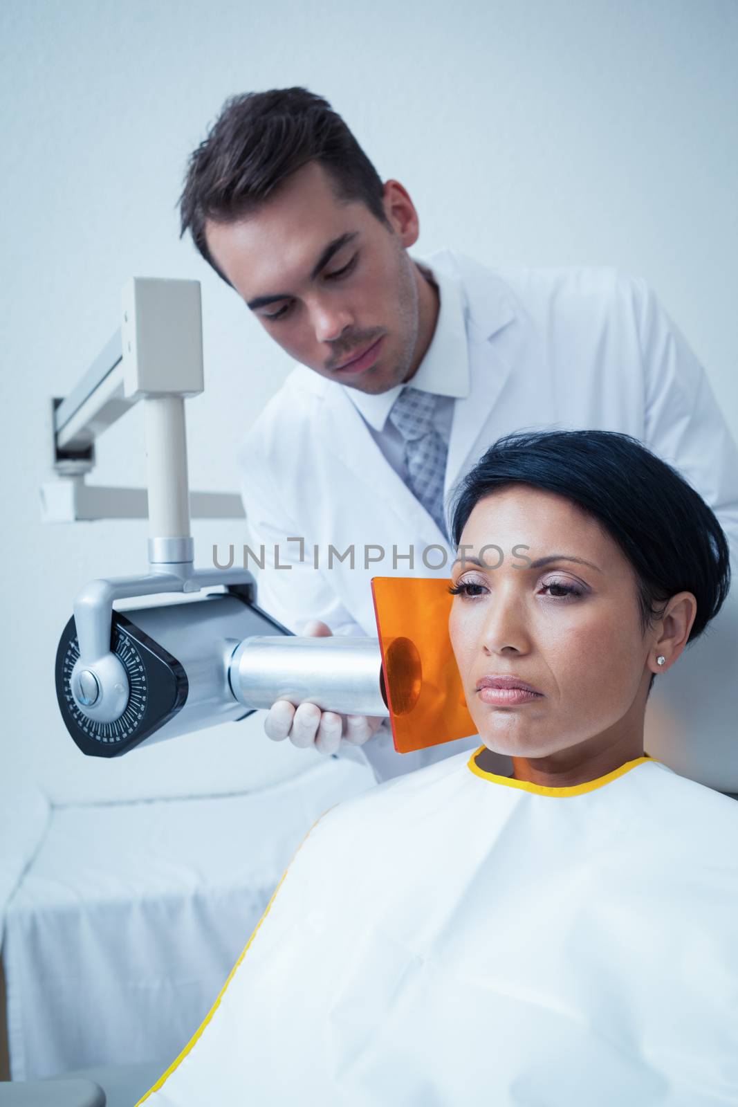 Serious young woman undergoing dental checkup in the dentists chair