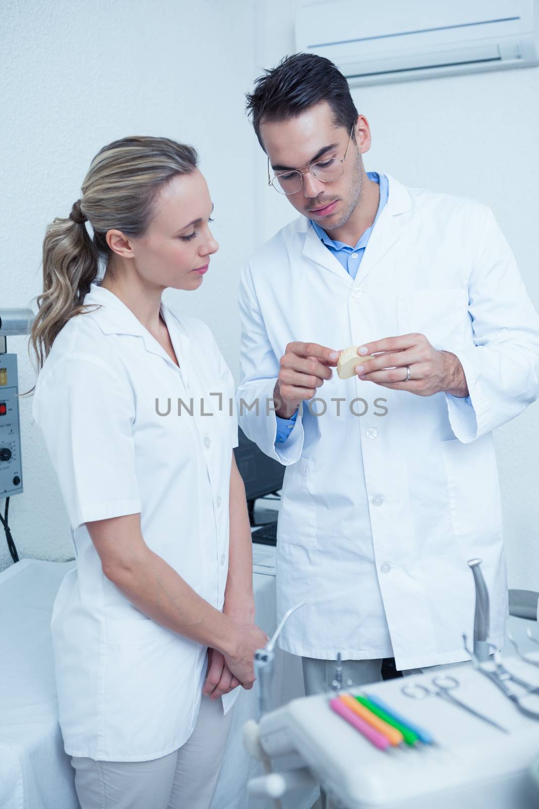 Concentrated two dentists looking at mouth model