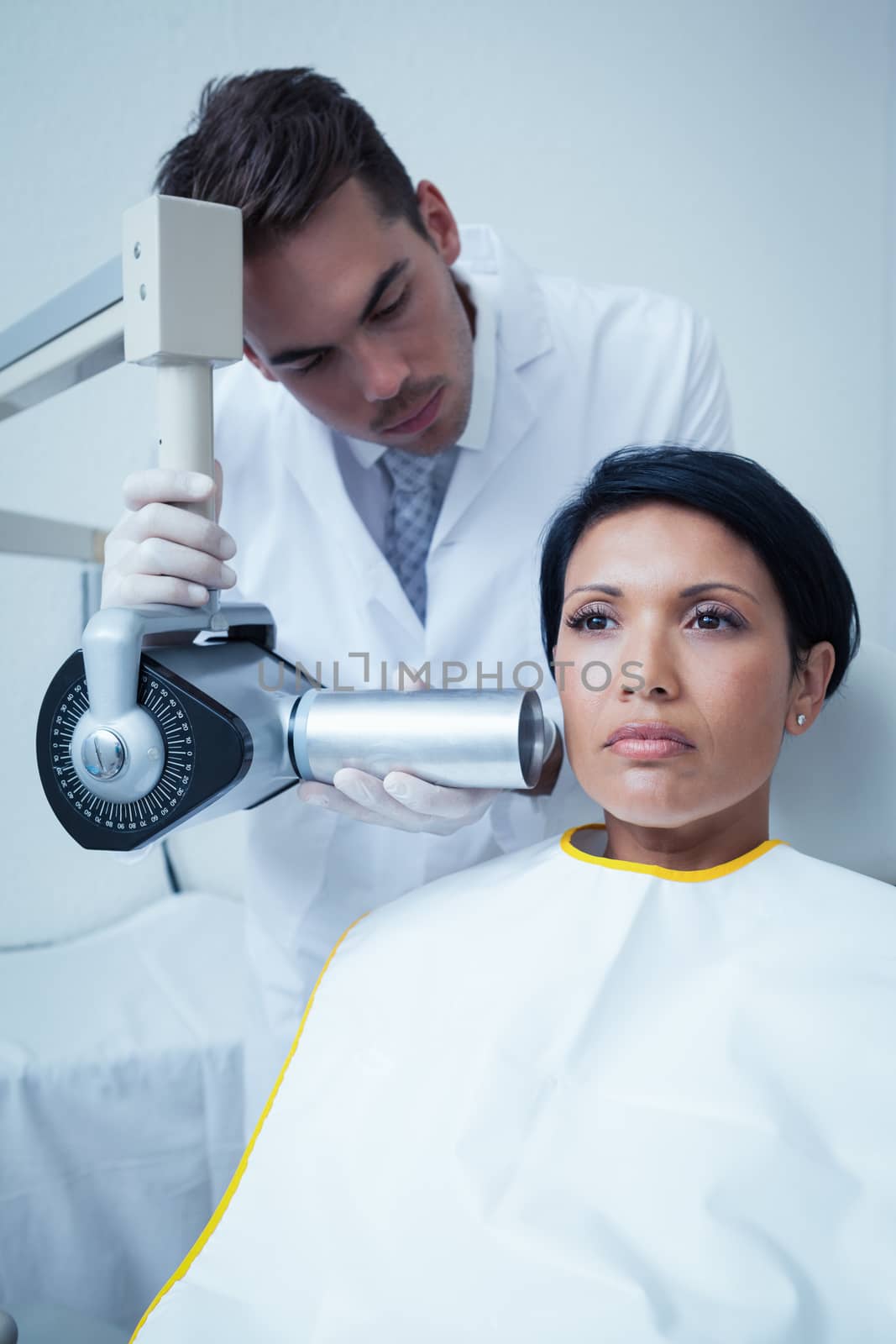 Serious young woman undergoing dental checkup in the dentists chair