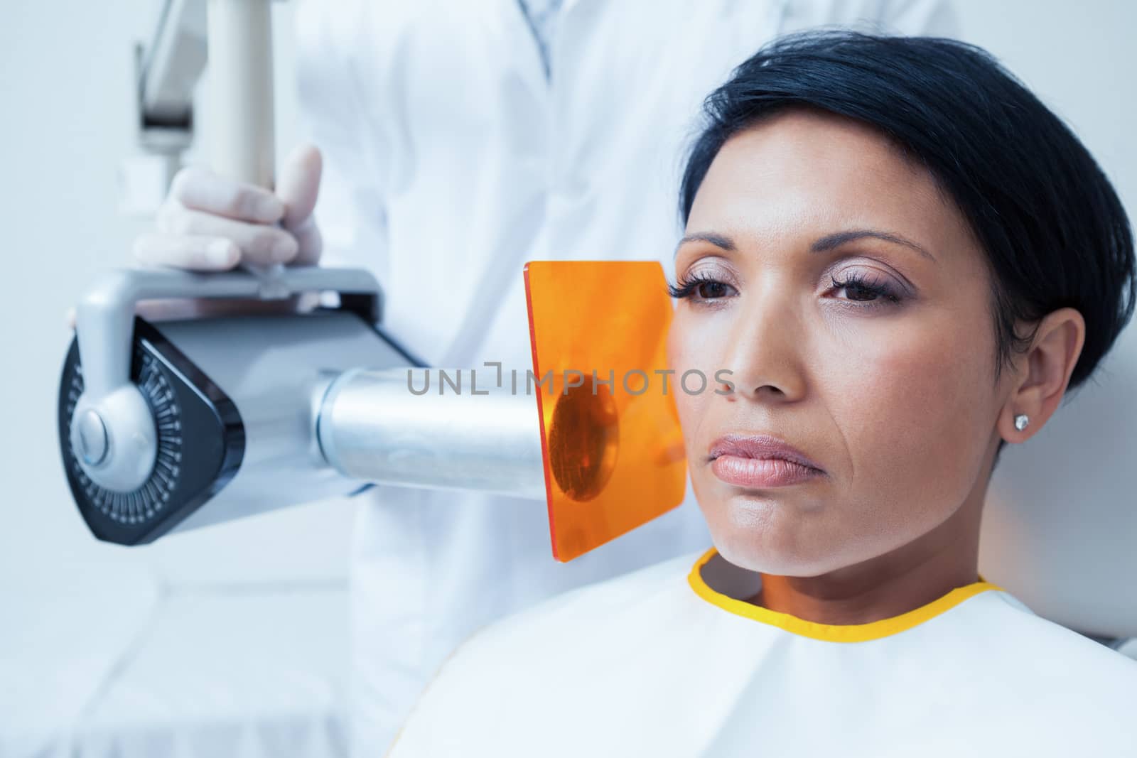 Serious young woman undergoing dental checkup in the dentists chair