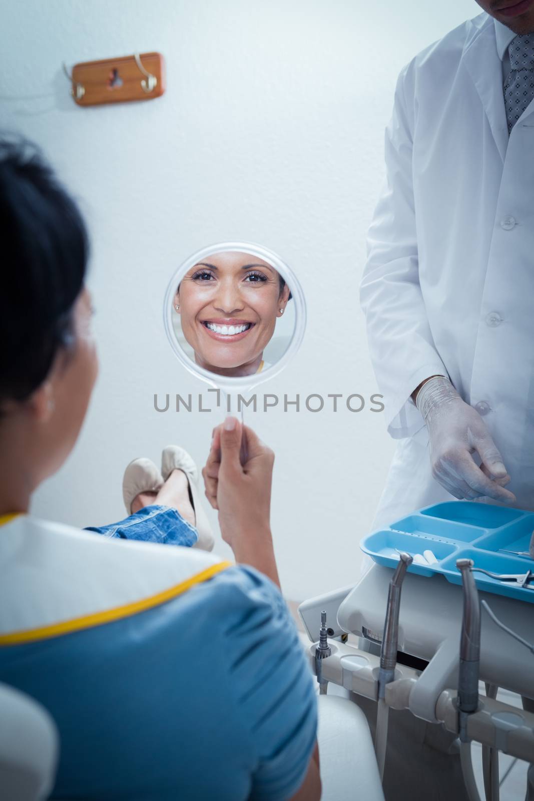 Smiling young woman looking at mirror by Wavebreakmedia