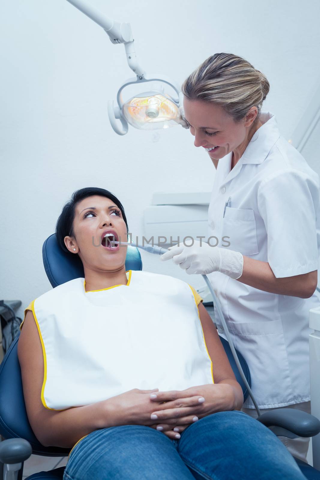 Female dentist examining womans teeth in the dentists chair
