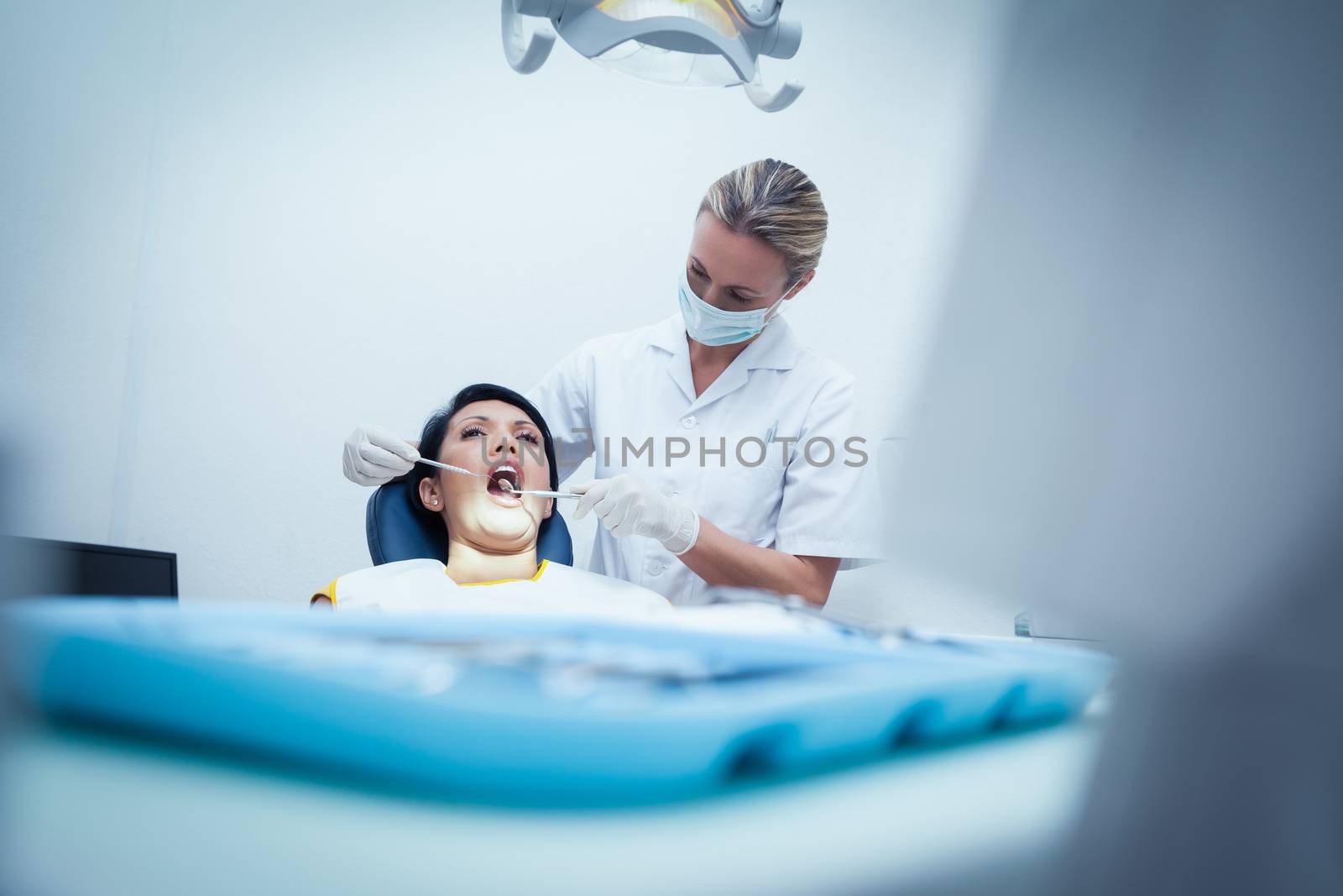 Female dentist examining womans teeth in the dentists chair