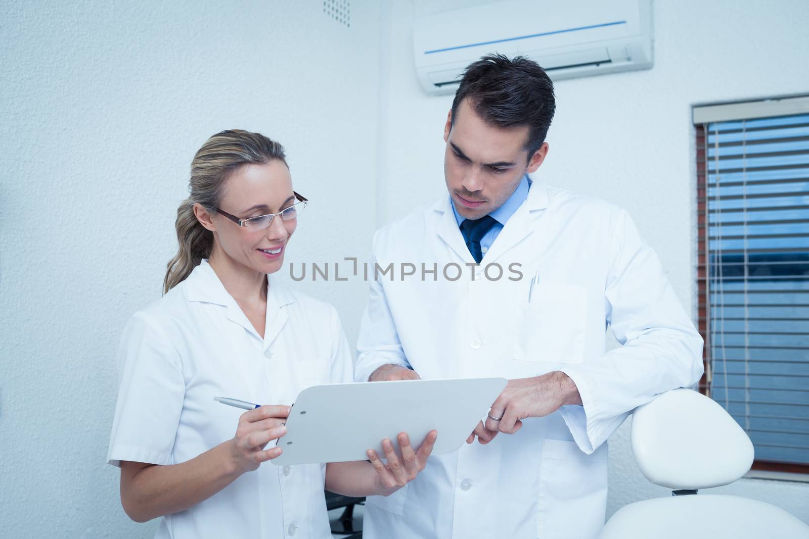 Dentists discussing reports by Wavebreakmedia