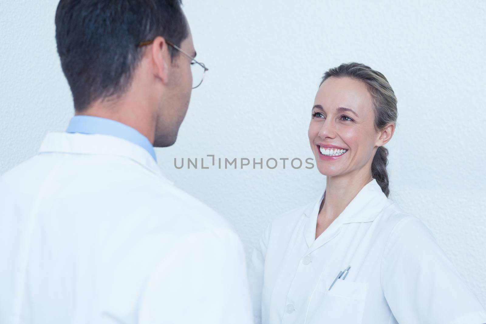 Smiling female and male dentists in discussion