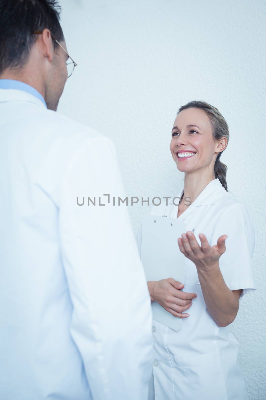 Smiling female and male dentists in discussion