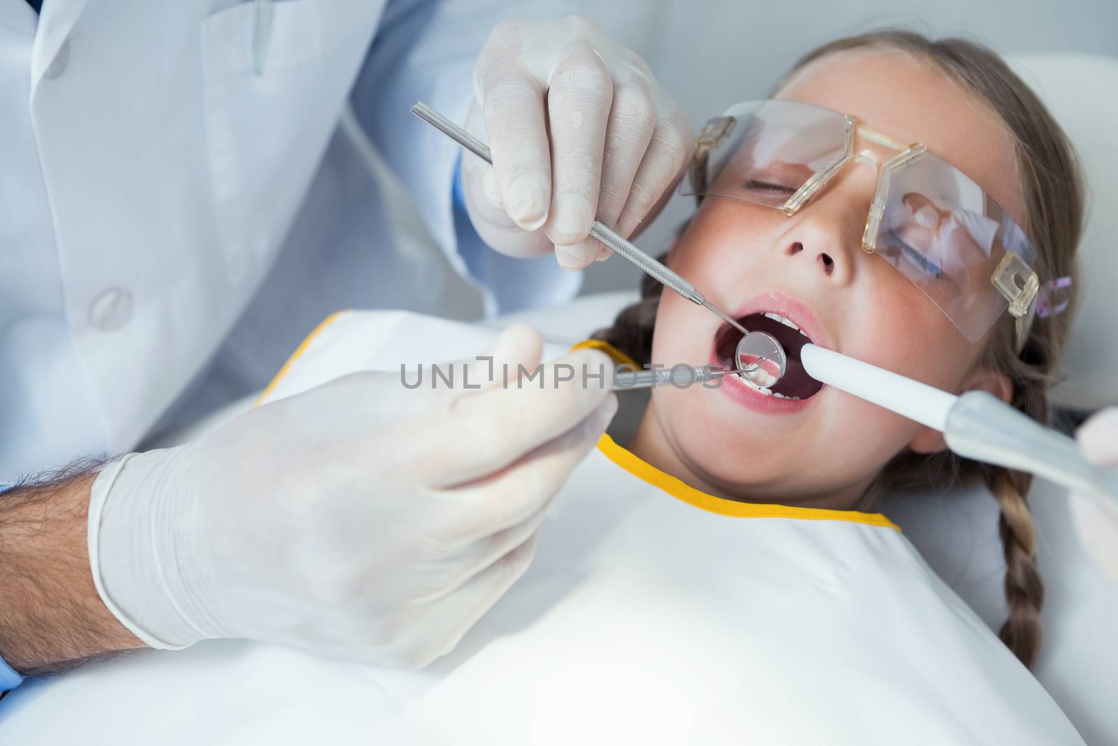 Close up of girl having her teeth examined by dentist