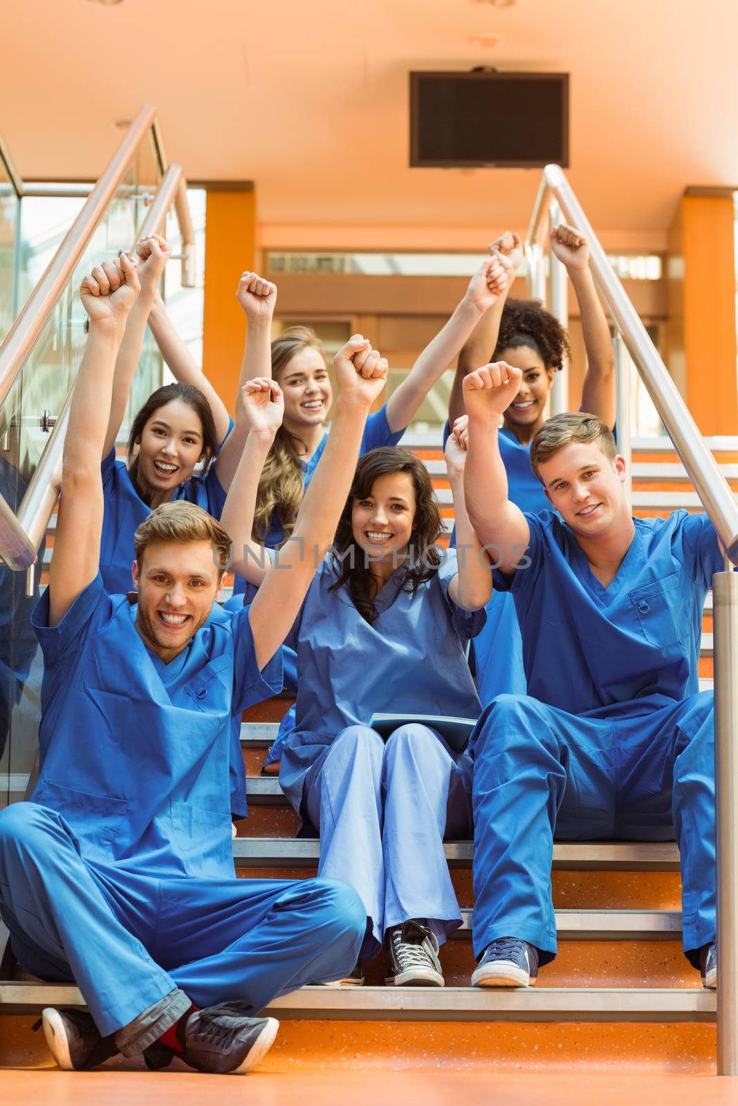 Medical students cheering on the steps by Wavebreakmedia