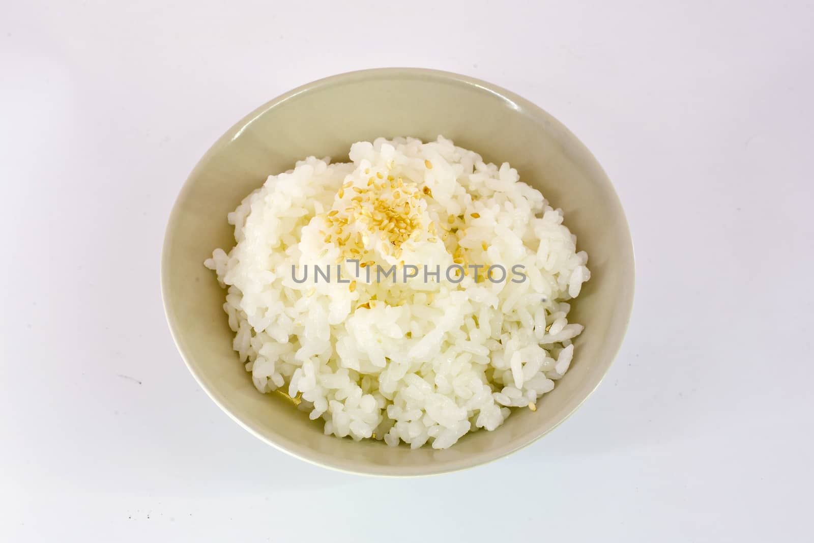 Cooked Rice topped with Sesame in white bowl isolate