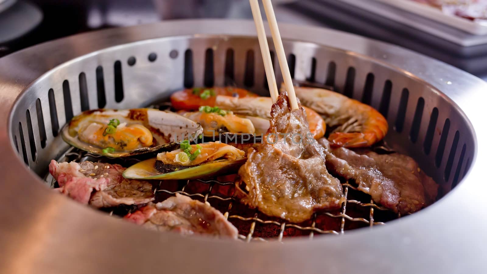 Mixed Roasted Meat and Seafood and Chopsticks on the BBQ Grill on roast.