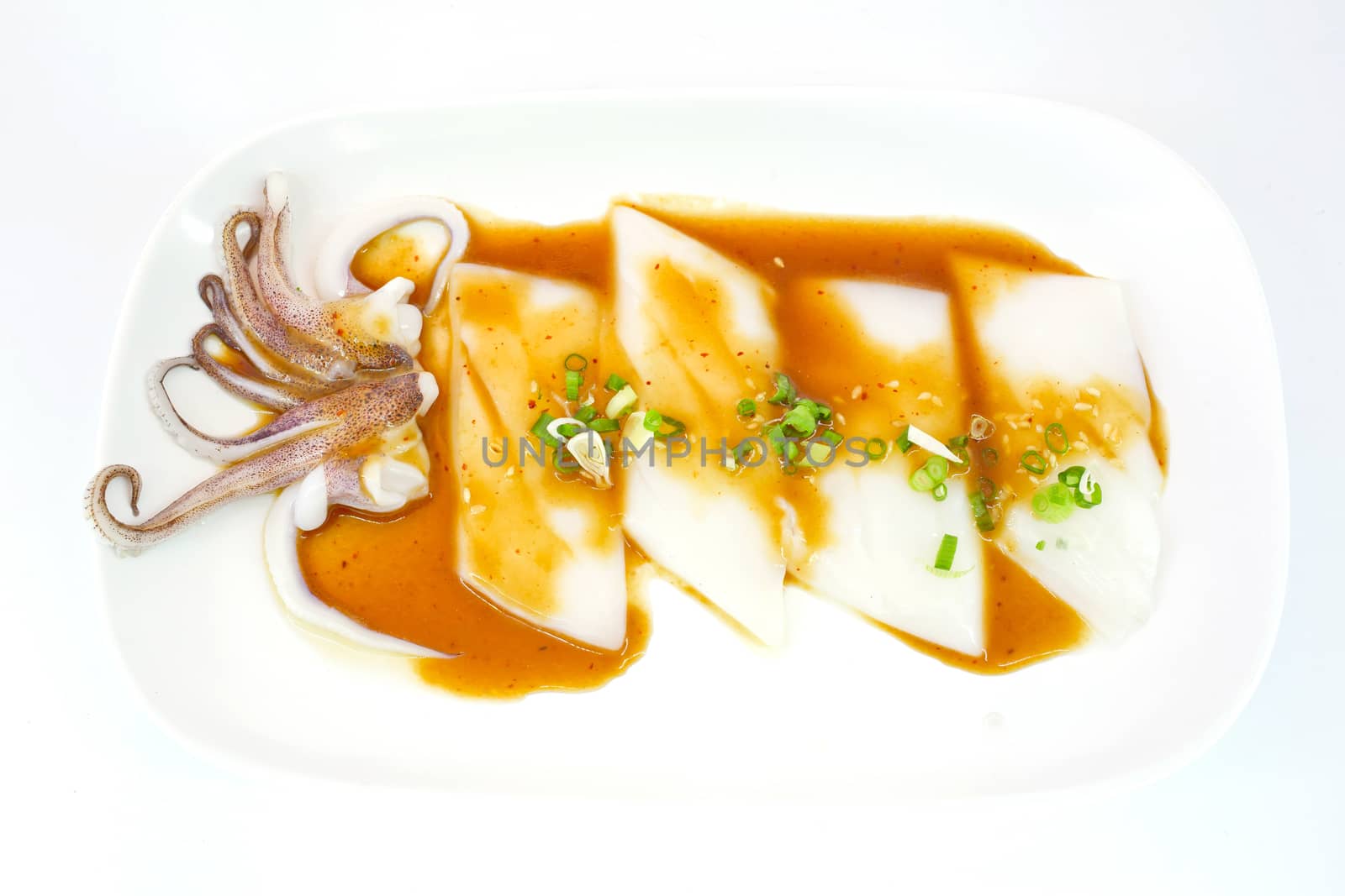 Raw squid slice on white dish isolate on white background ready to be grilled