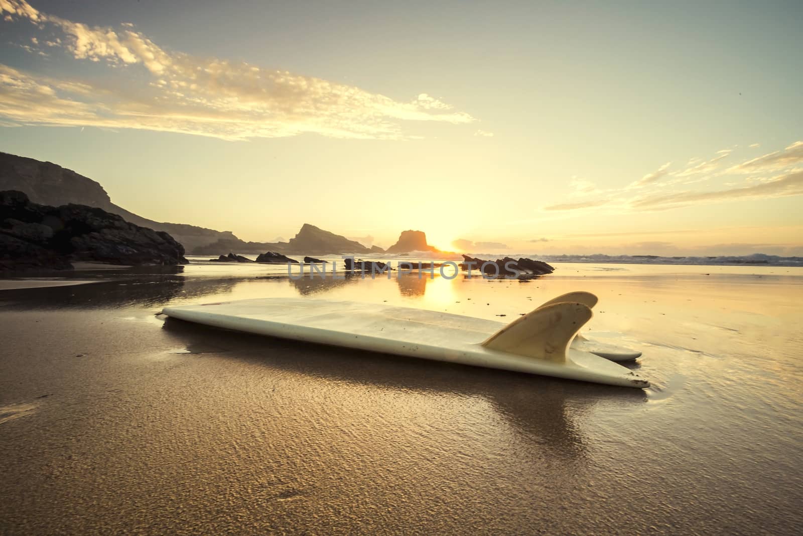 Silhouette of a surfboard at the beach with reflection 