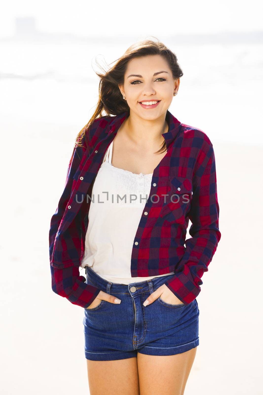 Beautiful and happy teen at the beach enjoying the summer