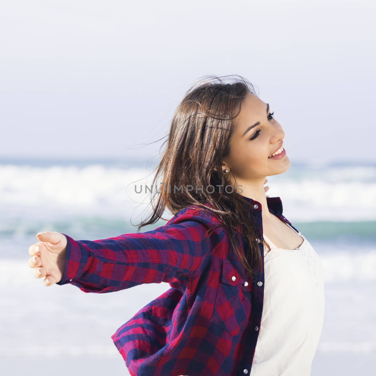 Beautiful and happy teen at the beach enjoying the summer